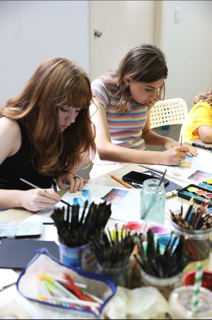 Two mini-artists concentrating on their watercolour paintings at Artlis Studios