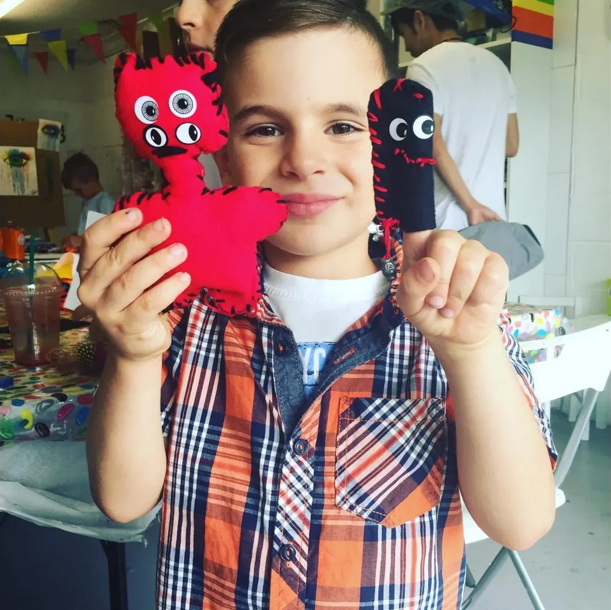 A child holding the art he made in art class