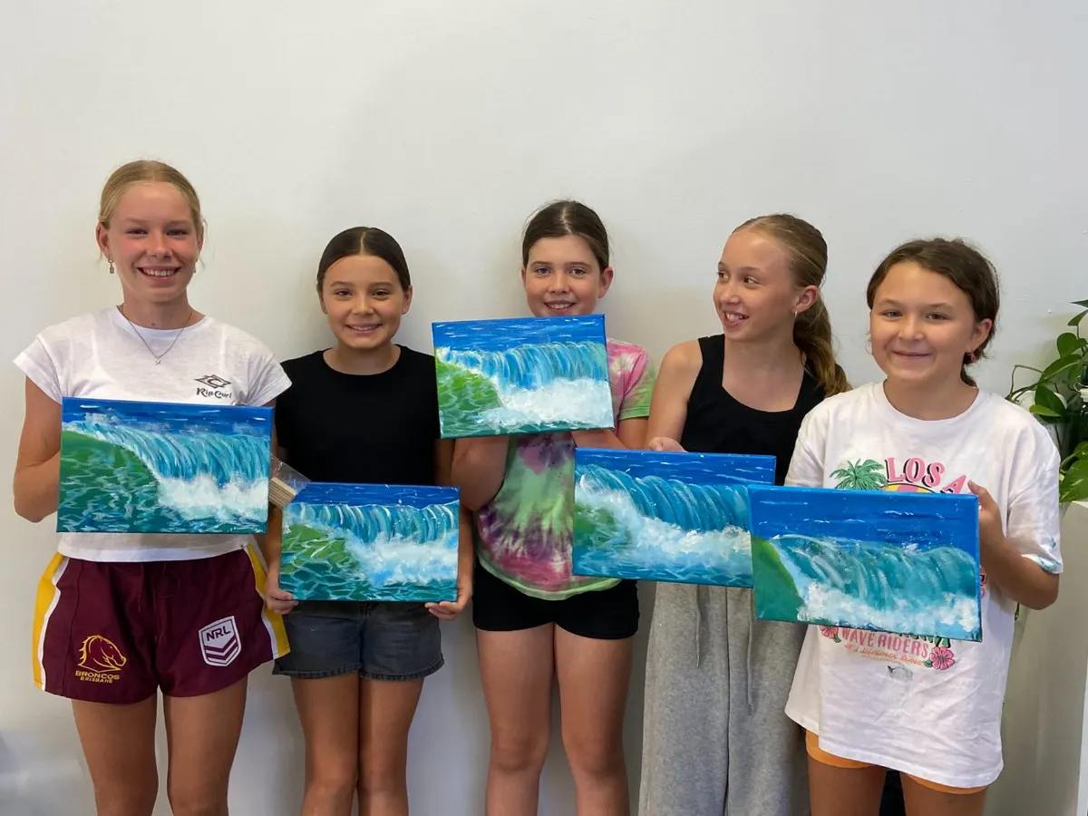 Five mini-artists holding up the wave canvases they painted